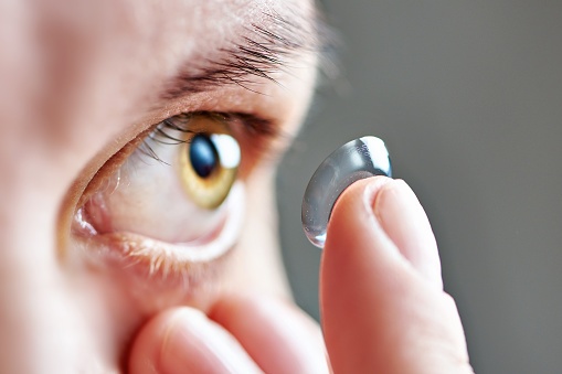 Young woman with astigmatism inserting a contact lens